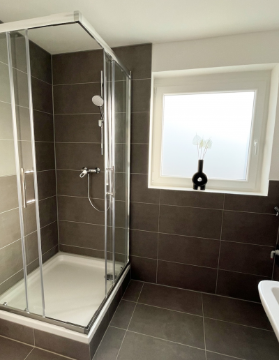Badezimmer mit Dusche und Fenster